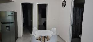 HuejotzingoDepartamento Aeropuerto Puebla的带冰箱的客房内的白色桌椅