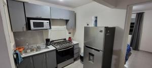 HuejotzingoDepartamento Aeropuerto Puebla的小厨房配有冰箱和微波炉。