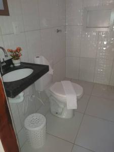 伊卡普伊Chalés Caiçara Praia de Ponta Grossa的白色的浴室设有卫生间和水槽。