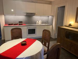 DaugmaleLauku māja Akmeņkalni的厨房配有一张带红白桌布的桌子