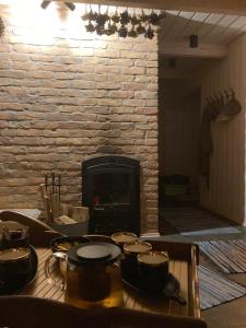 DaugmaleLauku māja Akmeņkalni的壁炉前的桌子,上面有锅碗瓢盆