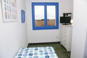 莱斯卡拉Pensió Solivent的一间卧室设有蓝色窗户和一张床