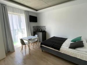 尼彻兹BLOMMA Niechorze的一间卧室配有一张床、一张桌子和一个窗户。