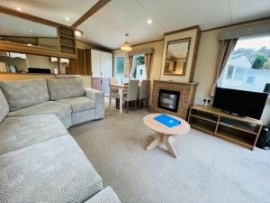 尚克林Luxury 2 Bedroom Caravan LG13, Shanklin, Isle of Wight的带沙发、电视和桌子的客厅