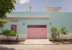 亨达Casa Celeste Honda的白色的建筑,有粉红色的门