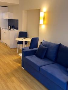 巴统The best beach aparthotel Orbi city Batumi的客厅配有蓝色的沙发和桌子