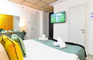 提比里亚Yalarent Malina motel in Tiberias的酒店客房,设有一张带平面电视的床铺。