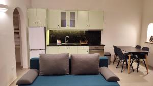IstérniaAelia Mare Penthouse的一间带蓝色沙发的客厅和一间厨房