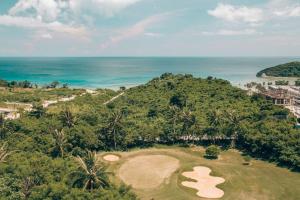 长滩岛Modern Tropical Luxe Apartment - Ilig-Iligan Beach的高尔夫球场和海洋的空中景致