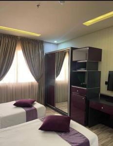 Abyār ‘Alīفندق نواة المدينة的酒店客房,设有两张床和镜子