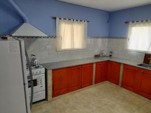 圣萨尔瓦多德朱La Glorieta -Casas de descanso的厨房配有红色橱柜和白色炉灶烤箱