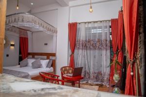 坎帕拉Green Villa Apartments的一间卧室配有床和红色窗帘