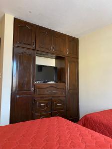 克萨尔特南戈Apartamento #3 Portal de Occidente的一间卧室设有大型木制橱柜和一张床