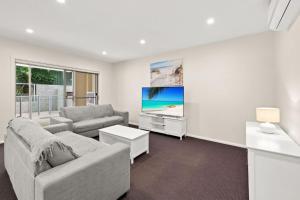 萨拉曼德湾Pacific Blue 520 private pool air conditioning and Wi Fi的带沙发和电视的客厅