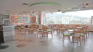 查亚普拉MaxOneHotels at Jayapura的餐厅设有桌椅和大窗户。