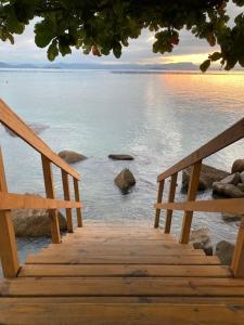 弗洛里亚诺波利斯Vila Verde casa com ar condicionado e vista da lagoa的通往水面的木楼梯,岩石
