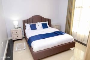 MeruLuxe Furnished Premium Unit的一间卧室配有一张带蓝白色床单的大床