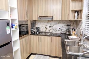 MeruLuxe Furnished Premium Unit的一个带木制橱柜和水槽的小厨房