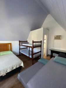 布希奥斯Chalés Búzios的一间卧室配有两张床和钢琴
