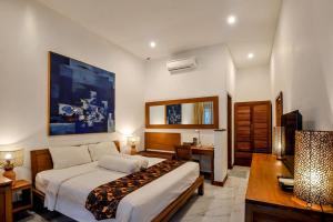 日惹Rumah Mertua Heritage的酒店客房配有一张床、一张书桌和一张西德西德西德西德床