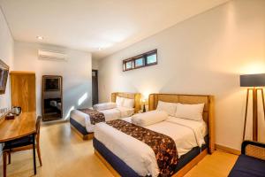 日惹Rumah Mertua Heritage的酒店客房配有两张床和一张书桌