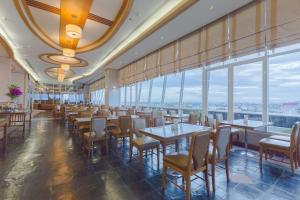 曼谷亚洲机场饭店 的餐厅设有桌椅和大窗户。