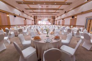 曼谷亚洲机场饭店 的一个带白色桌子和白色椅子的大型宴会厅