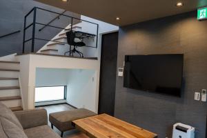 高松Second Home 瀬戸風月的客厅设有壁挂式平面电视。