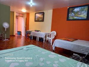 特鲁希略Casa Hospedaje San Miguel的一间设有两张床和一张桌子及椅子的房间