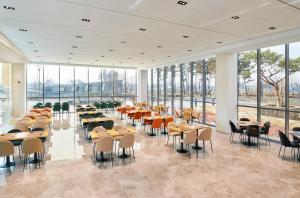 仁川市ibis Styles Ambassador Incheon Airport T2的用餐室设有桌椅和窗户。