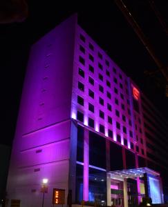 钦奈E酒店的一座晚上有紫色灯光的建筑