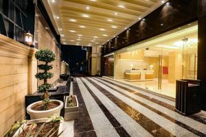 占西Regenta Place Jhansi by Royal Orchid Hotels Limited的走廊上,有盆栽植物的建筑和大堂