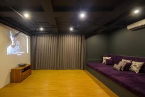 KetewelBeachfront Luxury, Villa Purnama的客厅配有紫色沙发和屏幕