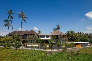 KetewelBeachfront Luxury, Villa Purnama的前面有棕榈树的房子