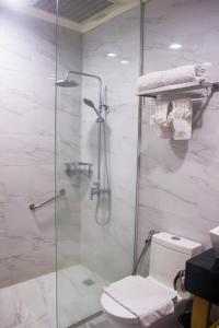 奥隆阿波Le Charmé Suites - Subic的浴室设有玻璃淋浴间和卫生间