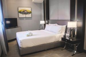 奥隆阿波Le Charmé Suites - Subic的一间卧室配有一张床和一台电视