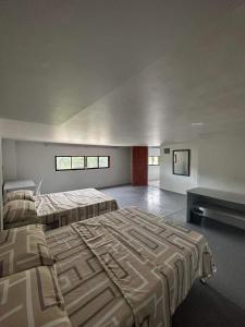RedDoorz at FJ Hotel Tubungan Iloilo的一间带两张床和一张沙发的大卧室