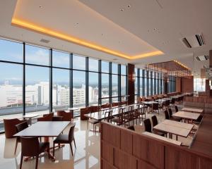 宇都宫Candeo Hotel Utsunomiya的餐厅设有桌椅和大窗户。