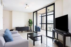 圣克鲁斯-德特内里费Apartamento Jade的客厅配有白色沙发和电视