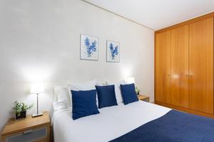 圣克鲁斯-德特内里费Apartamento Jade的卧室配有带蓝色枕头的大型白色床