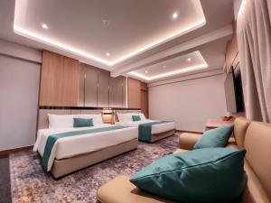 峇株巴辖Crystal Inn的酒店客房,设有两张床和一张沙发