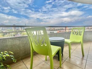 圣地亚哥Providencia Plaza的两把绿色椅子坐在一个美景阳台上