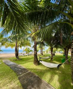 富国Gold Coast Phu Quoc Beach Resort的海滩上棕榈树荫下的吊床