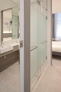 伦敦Heeton Concept Hotel - Kensington London的一间带玻璃淋浴和水槽的浴室