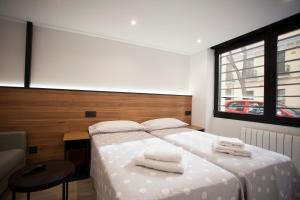 马德里CC Atocha Apartments的一间卧室配有一张床,上面有两条毛巾