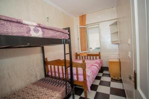 巴统Hostel California的一间卧室设有两张双层床和一张可调节的地板。
