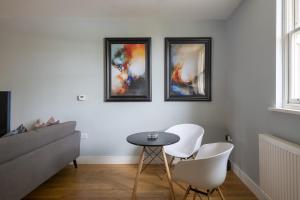 布伦特里Luxurious Private One Bedroom Apartment的客厅配有桌子和三张墙上的照片