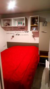 圣让-德蒙mh 4 chambres au calme Bois Dormant的墙上的红色床