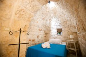 卡洛维诺Pietre Bianche的一间卧室,在石墙内配有一张蓝色的床