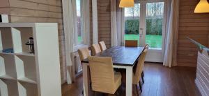 泽沃德The Black House - Luxurious Holiday Villa Zeewolde的一间带木桌和椅子的用餐室